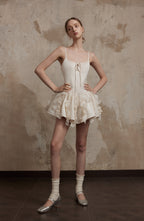 Nuvola Mousse Sun Dress styled with silver heels and socks, highlighting its flouncy silhouette and soft, cloud-like texture.